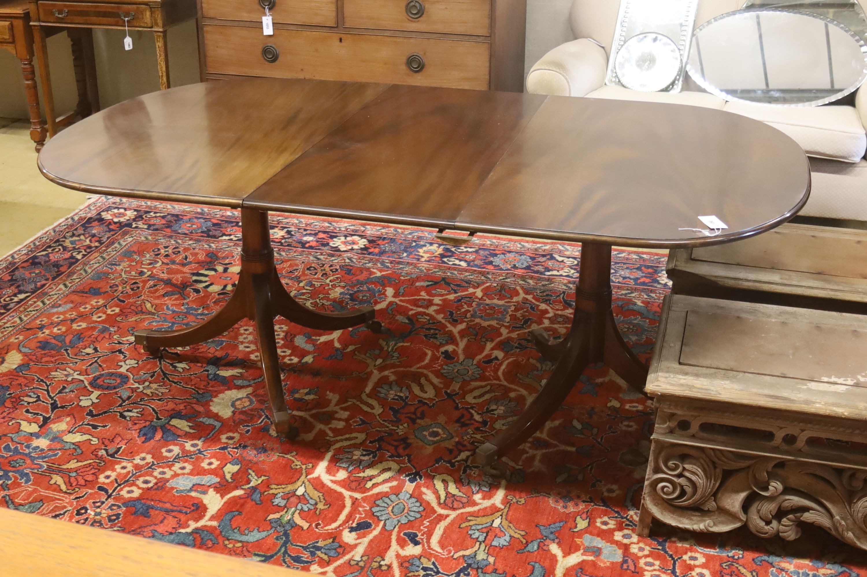 A William Tillman style reproduction mahogany twin pillar extending dining table, 186cm extended, (one spare leaf) width 106cm, height 73cm